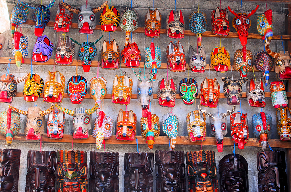 "Colorful wooden masks at Chichicastenango Market, a cultural treasure to explore on Guatemala Vacation Packages."
